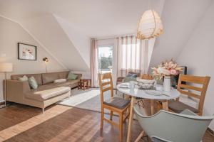 a living room with a table and a couch at FeWo Dünengrün in Trassenheide