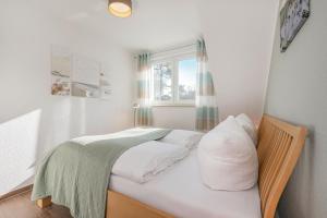 a small bedroom with a bed and a window at FeWo Dünengrün in Trassenheide