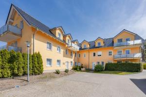a large apartment building with a driveway at FeWo Dünengrün in Trassenheide
