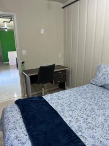 a bedroom with a bed and a desk and a chair at Casa Container Completa e Privativa em Sombrio-SC in Sombrio