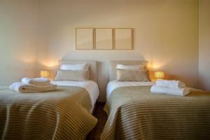 two beds in a room with towels on them at Step by Step Atlantic Guesthouse in Vila do Conde