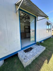 a home with a large glass door and a patio at Casa Container Completa e Privativa em Sombrio-SC in Sombrio