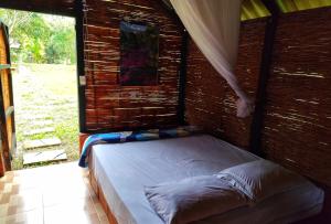 a bed in a room with a window at Ecopradera Lodge in San José del Guaviare