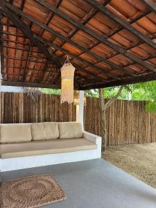 a couch sitting under a pergola in a patio at Casa Pema - Grupo Casa Camurupim in Barra Grande