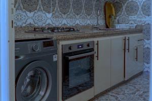 a kitchen with a stove and a washing machine at COZY APPARTEMENT Center city 11 janvier in Casablanca