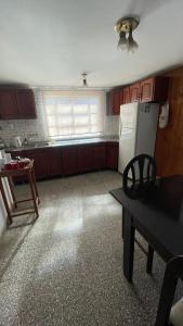 a kitchen with a refrigerator and a table in it at Casa Rivadavia in Rafaela