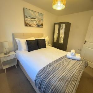 a bedroom with a large white bed and a mirror at NJ&C Properties in Bristol