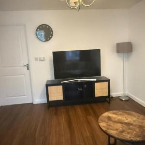 a living room with a flat screen tv and a table at NJ&C Properties in Bristol