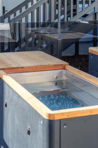 a table with a pool of water in the middle at Waves & Wellness - Spa Pool and Parking in Christchurch +16 photos