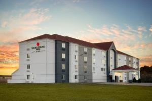 a rendering of a building with a sunset in the background at Candlewood Suites - Topeka West by IHG in Topeka