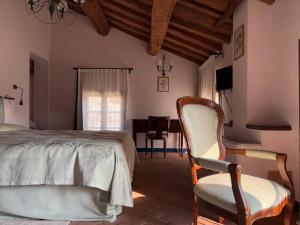 a bedroom with a bed and a chair and a table at Agriturismo Ca' Guerriera in Sustinente