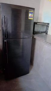 a black refrigerator in a kitchen next to a microwave at Kenzy House Abu Simbel in Abu Simbel