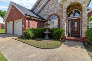a brick house with a fountain in the driveway at Casa Oasis Extra Large home centrally located in Springdale