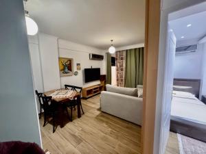 a room with a bed and a couch and a table at Aisha Apartment in Berat
