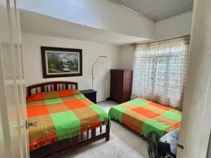 a bedroom with two beds and a window at Casa de campo los anturios in La Tebaida