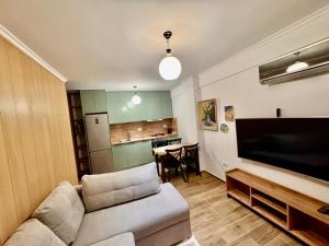 a living room with a couch and a flat screen tv at Aisha Apartment in Berat