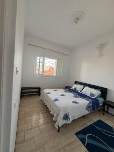 a bedroom with a bed and a window at Maison front de mer in El Jadida