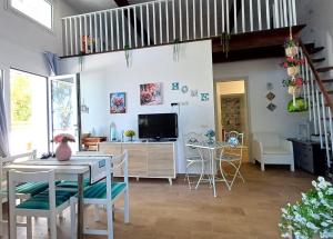a living room with a table and chairs and a television at Oikos Terrasini in Terrasini