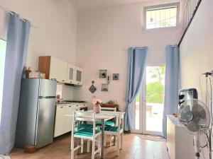 a kitchen with a refrigerator and a table with chairs at Oikos Terrasini in Terrasini