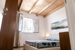 a bedroom with a bed and a window at Oikos Terrasini in Terrasini