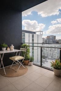 a balcony with a desk and a view of a city at Bedroom with Private Bathroom in cozy shared appartment! in Brisbane