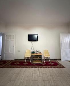 a room with two chairs and a tv on a wall at Maison front de mer in El Jadida