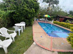 a pool with chairs and a table and an umbrella at Casa de campo los anturios in La Tebaida +17 photos