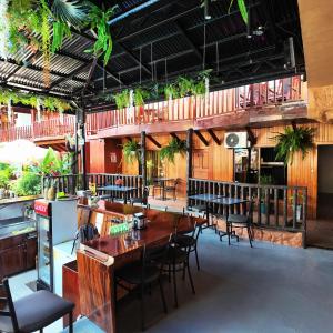 a restaurant with a table and chairs and plants at Poshtel Arenal in Fortuna