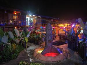 a fountain in the yard of a restaurant at night at Poshtel Arenal in Fortuna