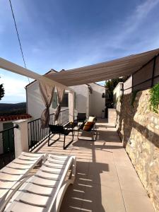 a patio with a canopy and chairs on a balcony at Tina's Sunset Haven in Ustrine