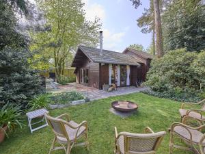 a backyard with chairs and a table and a house at Zee van tijd in Kasterlee