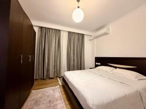 a bedroom with a large white bed and a window at Aisha Apartment in Berat