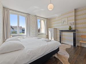 a bedroom with a large bed and a fireplace at La Maison Bleue Ronse in Ronse