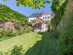 an alley in a garden with a building at La Maison Bleue Ronse in Ronse