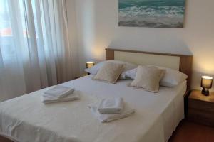 a bedroom with a bed with two towels on it at Apartments with parking space Slatine, Ciovo - 16731 in Slatine