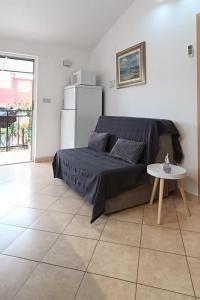 a room with a bed and a table and a refrigerator at Apartments with parking space Slatine, Ciovo - 16732 in Slatine