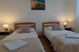 two beds in a room with two lamps on tables at Apartments with parking space Slatine, Ciovo - 16732 in Slatine