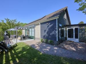 a blue house with a bench in the yard at Scheldeoord 54 in Baarland