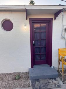 a purple door on a white building with a bench at Downtown Purple Apartment in Phoenix