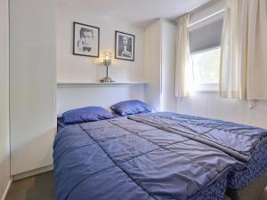 a bedroom with a bed with blue sheets and a window at L Etage in Kaatsheuvel +34 photos