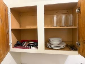 a cabinet with plates and dishes in it at Downtown Purple Apartment in Phoenix