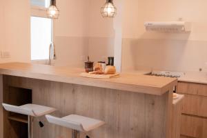 a kitchen with a counter with two stools at Epoca in Tandil +20 photos