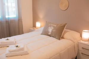 a white bed with towels on it in a room at Epoca in Tandil
