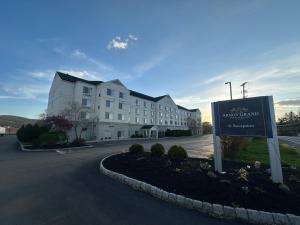 a large building with a sign in front of it at Arnot Grand Hotel & Suites in Horseheads