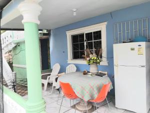 a blue kitchen with a table and a refrigerator at Powell's guesthouse in Santa Cruz