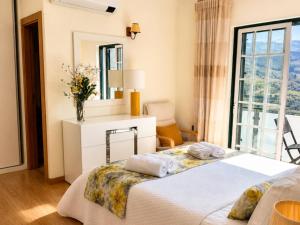 a bedroom with two beds and a mirror at Vivenda Portela in Covelinhas