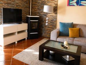 a living room with a couch and a tv at Vivenda Portela in Covelinhas