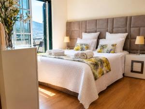 a bedroom with a large bed with a large window at Vivenda Portela in Covelinhas