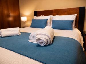 a bed with a rolled up towel on it at Vivenda Portela in Covelinhas +29 photos