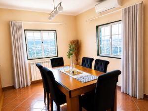 a dining room with a wooden table and chairs at Vivenda Portela in Covelinhas